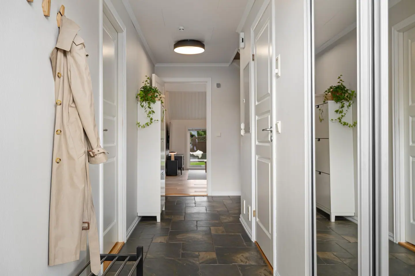 Gang med skyvedørsgarderobe og adkomst videre inn til oppholdsrommene.