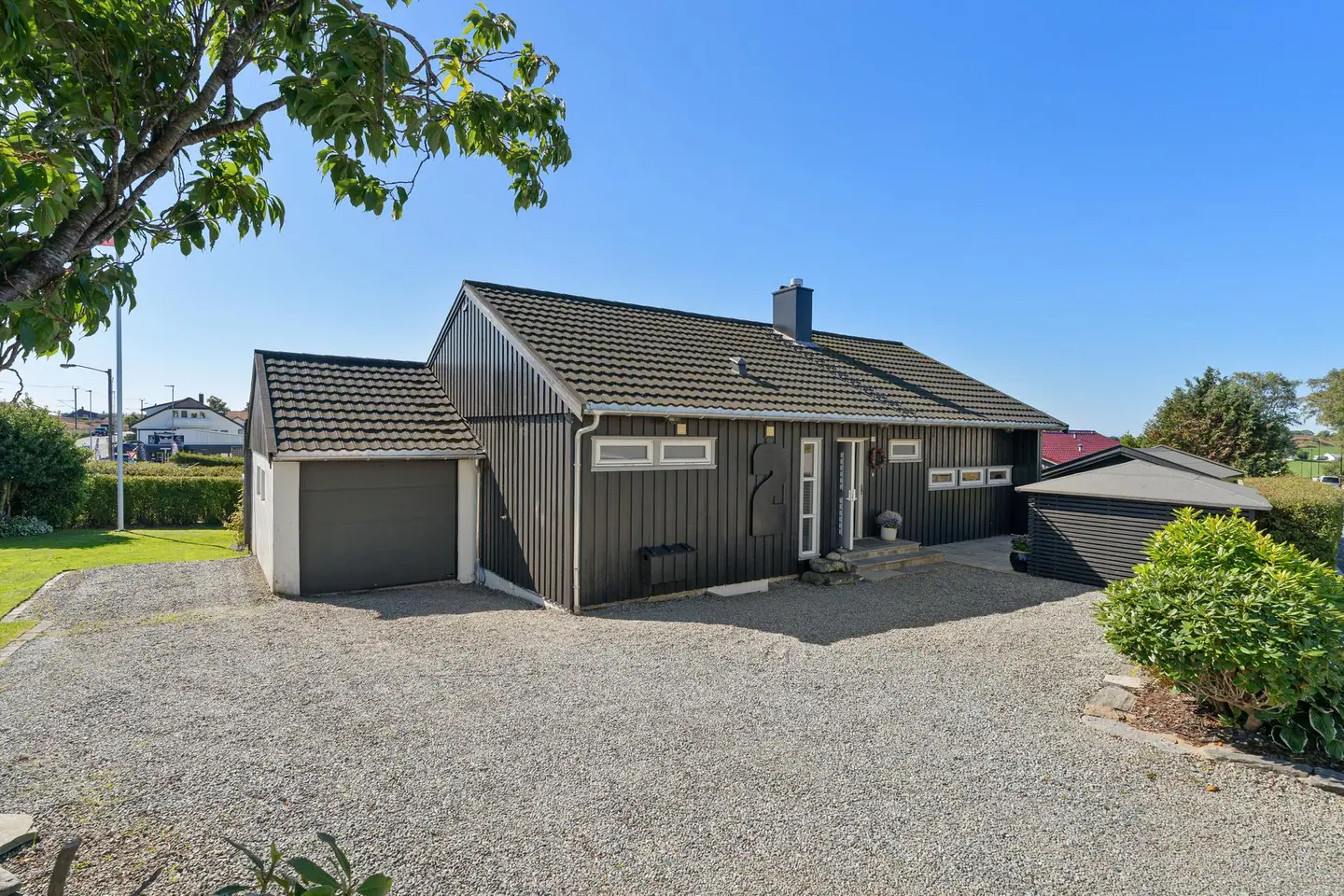 Innholdsrik enebolig over to plan med opparbeidet hage, stor veranda og integrert garasje.