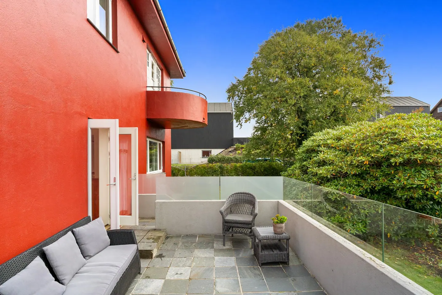 Skiferbelagt terrasse med god plass til sittegruppe og direkte utgang fra stuen.