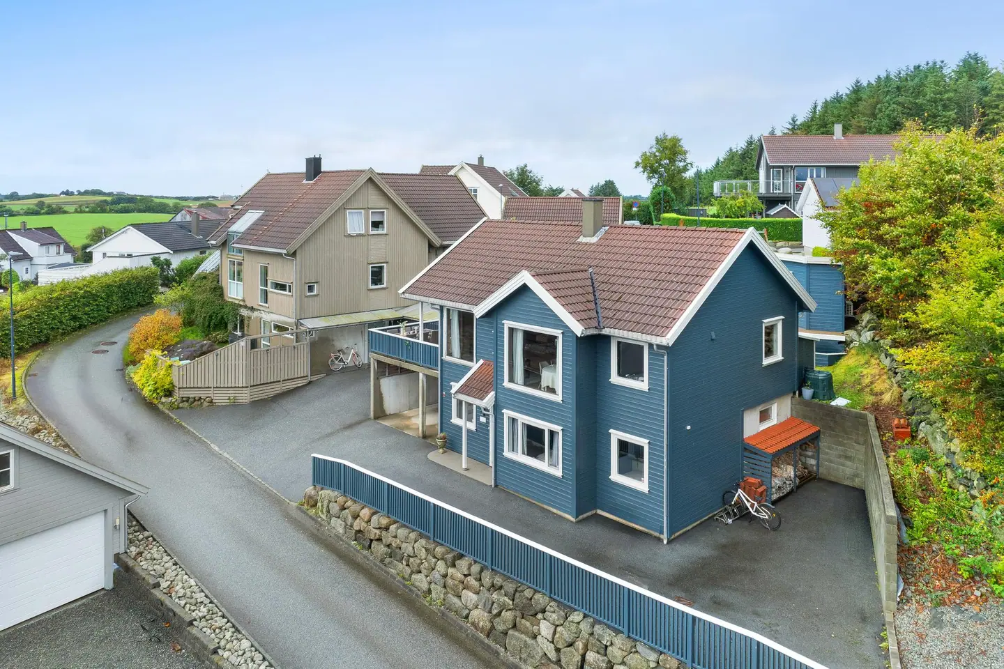 Innholdsrik enebolig over to plan med carport, asfaltert gårdsrom og pent opparbeidet tomt.