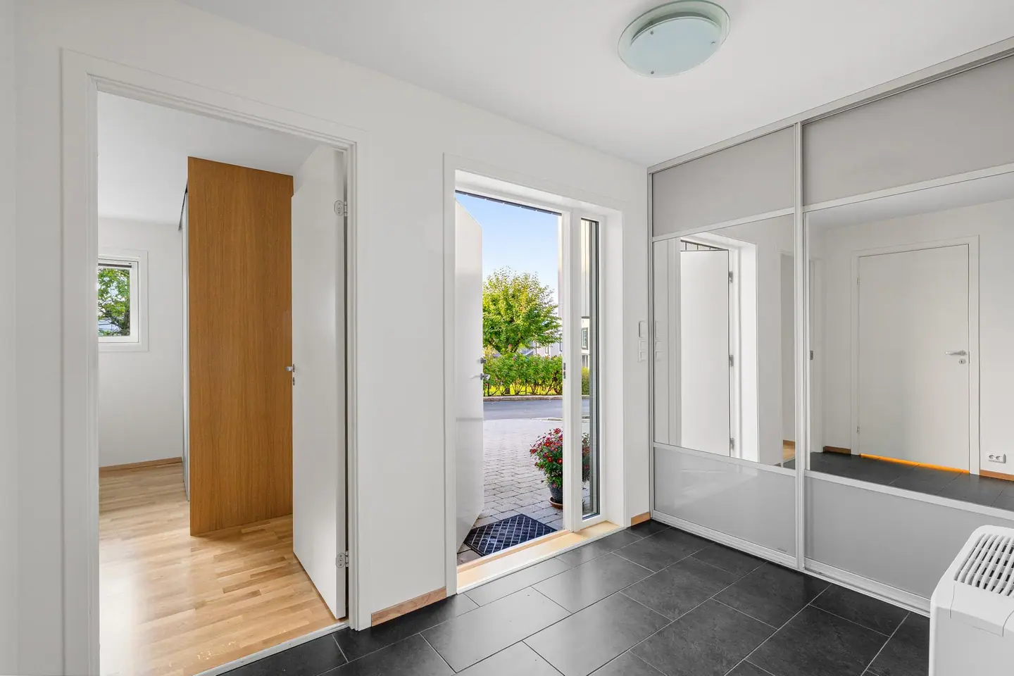 Velkommen inn. Inngangspartiet har flislagt gulv og skyvedørsgarderobe.