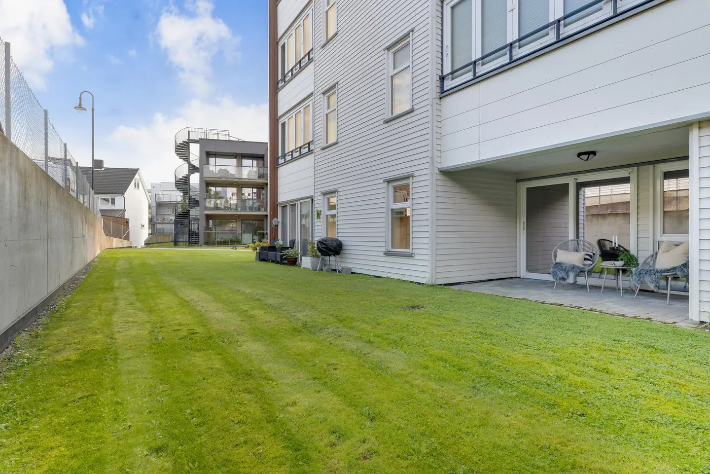 Uteplassen grenser direkte til felles plenareal på baksiden av bygget.