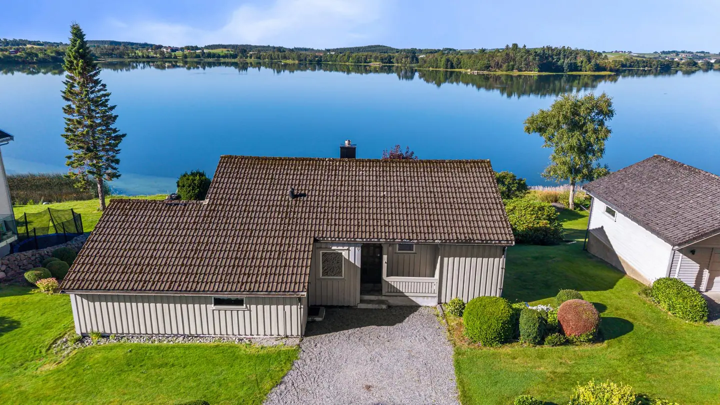 Eiendommen sett fra luften, med sin flotte plassering ved vannkanten.