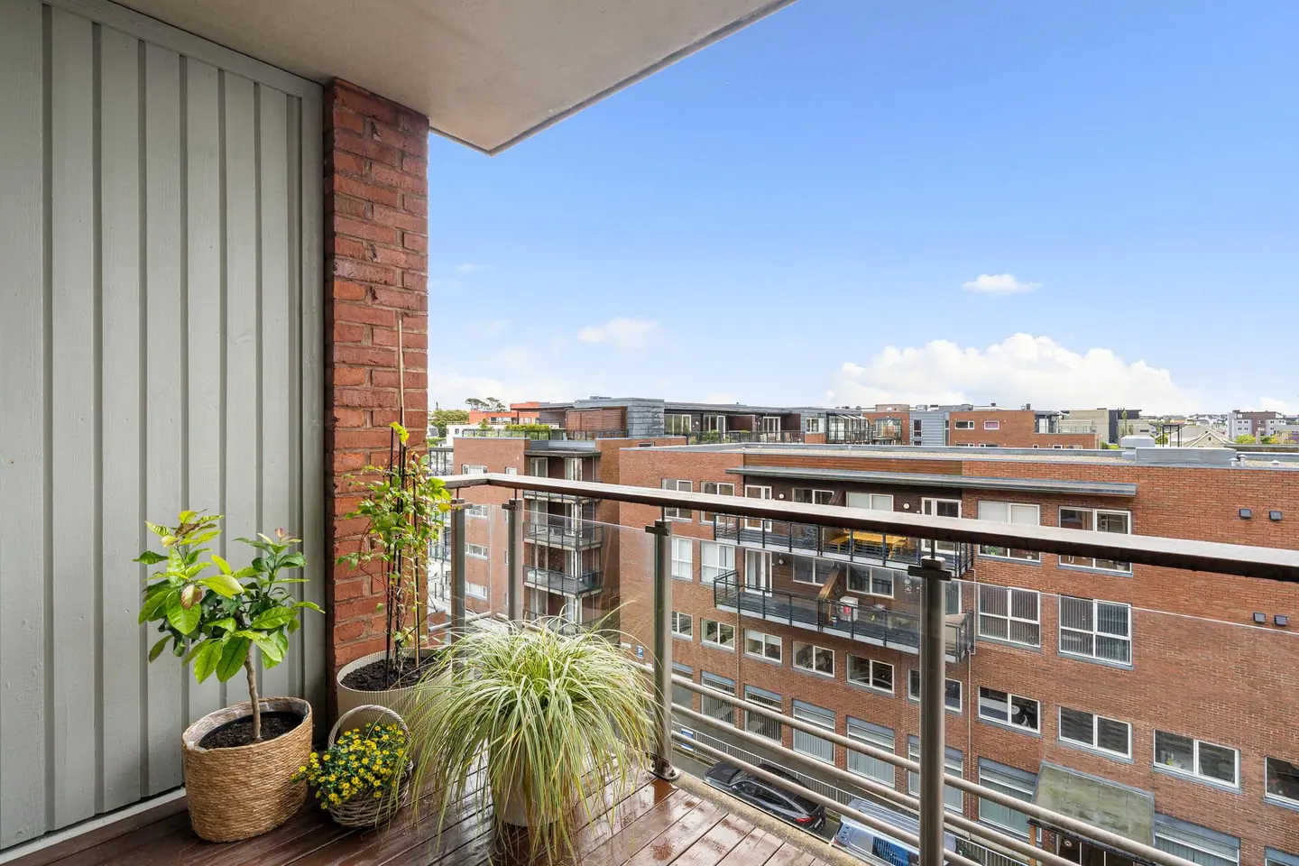 Skjermet uteplass under tak med rekkverk av glass og aluminium.